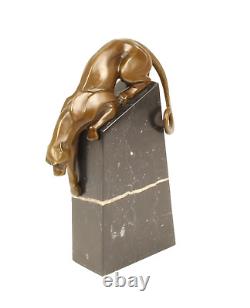 A bronze sculpture of a descending panther on a black marble signed