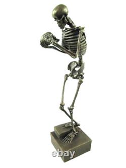 Antique bronze skeleton figurine on black marble