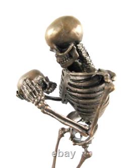 Antique bronze skeleton figurine on black marble