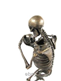 Antique bronze skeleton figurine on black marble