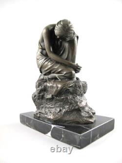 Antique sculpture of a kneeling woman in bronze on black marble