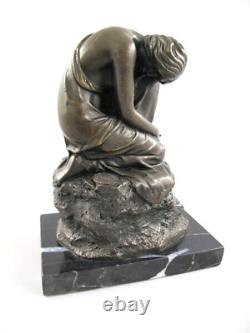 Antique sculpture of a kneeling woman in bronze on black marble