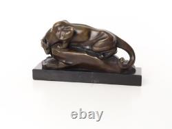 Bronze cougar statue by the pool on a black marble base, signed