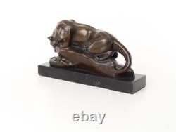 Bronze cougar statue by the pool on a black marble base, signed