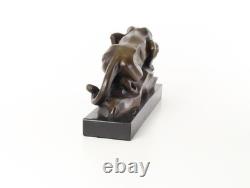 Bronze cougar statue by the pool on a black marble base, signed