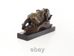Bronze cougar statue by the pool on a black marble base, signed