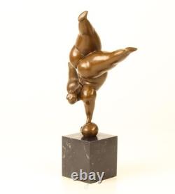 Bronze sculpture of a lady balancing on a black marble base after Milo