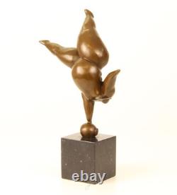 Bronze sculpture of a lady balancing on a black marble base after Milo