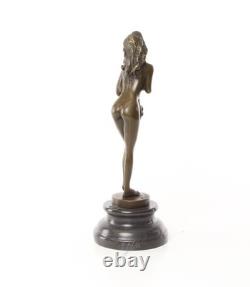 Bronze sculpture of a nude woman on a black marble pedestal Signed