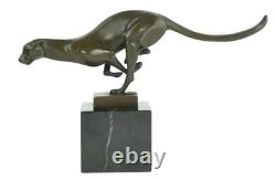 Bronze sculpture of a running cheetah on a black marble base, signed