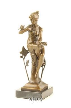 Bronze sculpture of a seated lady with a bird on a black marble base after Nick