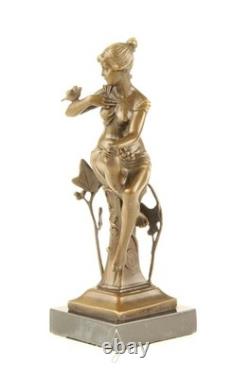 Bronze sculpture of a seated lady with a bird on a black marble base after Nick