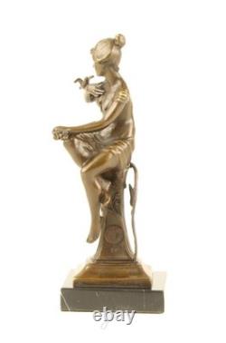 Bronze sculpture of a seated lady with a bird on a black marble base after Nick