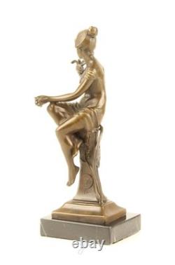 Bronze sculpture of a seated lady with a bird on a black marble base after Nick