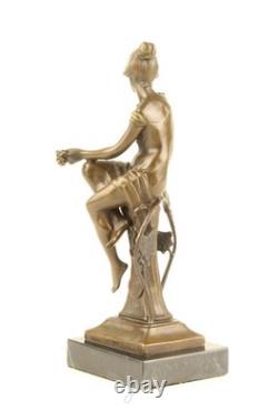 Bronze sculpture of a seated lady with a bird on a black marble base after Nick