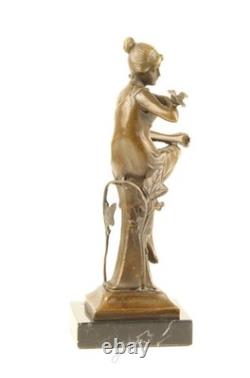Bronze sculpture of a seated lady with a bird on a black marble base after Nick
