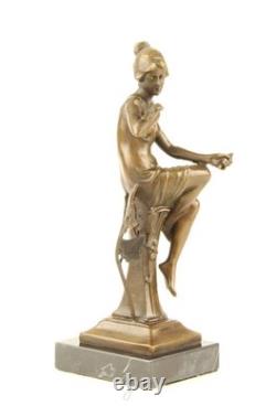 Bronze sculpture of a seated lady with a bird on a black marble base after Nick