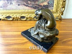 Bronze sculpture of a seated woman on a black marble base after Milo