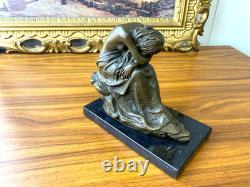 Bronze sculpture of a seated woman on a black marble base after Milo