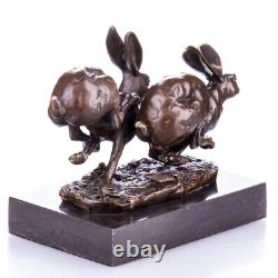 Bronze sculpture of racing rabbits on a black marble base after Nick