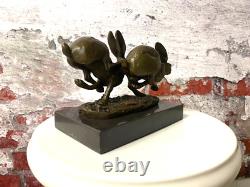 Bronze sculpture of running rabbits on a black marble base after Nick