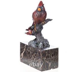 Colorful bronze bird sculpture on a branch on a Vintage signed marble