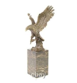 Eagle sculpture with fish in bronze on black marble after Milo