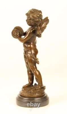 Sculpture of a Putto playing Cymbals in bronze on black marble signed