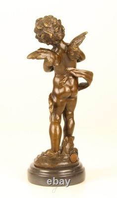 Sculpture of a Putto playing Cymbals in bronze on black marble signed