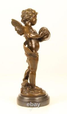Sculpture of a Putto playing Cymbals in bronze on black marble signed