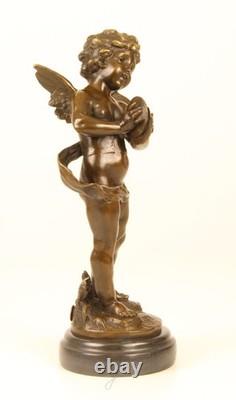 Sculpture of a Putto playing Cymbals in bronze on black marble signed