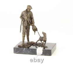 Sculpture of a hunter with a dog on black marble signed