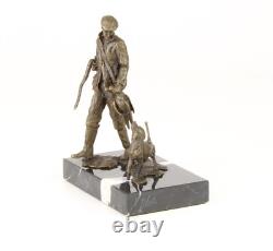 Sculpture of a hunter with a dog on black marble signed