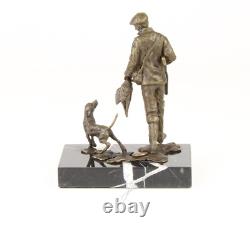 Sculpture of a hunter with a dog on black marble signed