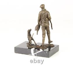 Sculpture of a hunter with a dog on black marble signed
