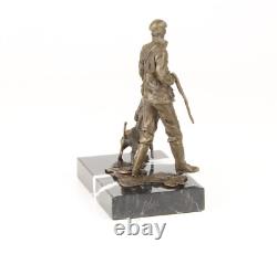 Sculpture of a hunter with a dog on black marble signed
