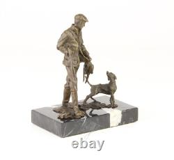 Sculpture of a hunter with a dog on black marble signed