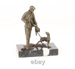 Sculpture of a hunter with a dog on black marble signed