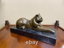 Sculpture of a modern reclining cat on black marble by Michel Decoux