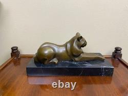 Sculpture of a modern reclining cat on black marble by Michel Decoux