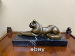 Sculpture of a modern reclining cat on black marble by Michel Decoux