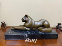 Sculpture of a modern reclining cat on black marble by Michel Decoux