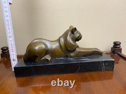 Sculpture of a modern reclining cat on black marble by Michel Decoux