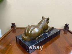 Sculpture of a modern reclining cat on black marble by Michel Decoux