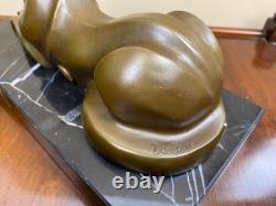 Sculpture of a modern reclining cat on black marble by Michel Decoux