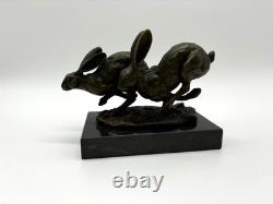 Sculpture of running hares in bronze on a black marble base after Nick