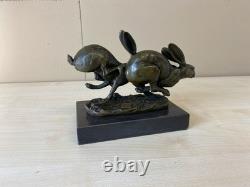Sculpture of running hares in bronze on a black marble base after Nick