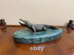 Shared bronze crocodile sculpture on a green marble base after Milo