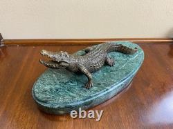 Shared bronze crocodile sculpture on a green marble base after Milo