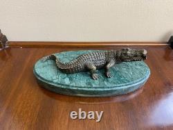 Shared bronze crocodile sculpture on a green marble base after Milo